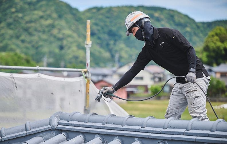 屋根を塗装する職人